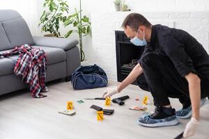 Criminological expert collecting evidence at the crime scene. photo