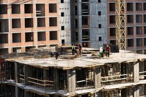 concreting work. construction site worker during concrete pouring into formwork at building area with skip photo