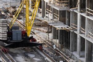 concreting work. construction site worker during concrete pouring into formwork at building area with skip photo