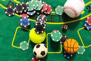 Conceptual background of online sports betting with objects representing different sports, money and chips to bet. Front view. photo