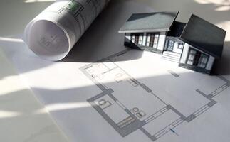 building house on blueprints with worker construction project photo