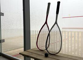 Sports, above and racket on squash court for competition, challenge and training center. Exercise, interior and empty room with top view of wooden floor of gymnasium for games, fitness club and gear photo
