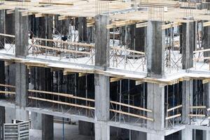 concreting work. construction site worker during concrete pouring into formwork at building area with skip photo