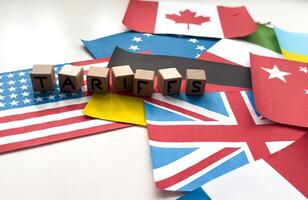 wooden cube block for tariffs on flags of different countries photo