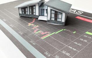 miniature house models on graph indicating growth in real estate prices market photo