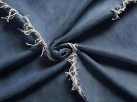 A macro capture of denim with visible fraying and loose, hanging threads. photo