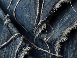 A high-definition view of worn denim, showing fraying and loose fibers. photo