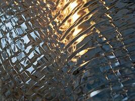 A creative close up of light reflections distorted through rippled glass. photo