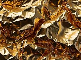 A detailed macro of wrinkled gold foil with rich, shimmering reflections. photo