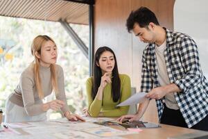 Diverse team analyzing design materials and discussing concepts in an office. photo