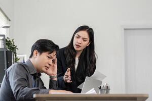 Female professional expressing concern while male colleague shows signs of stress during a project discussion in the office. photo