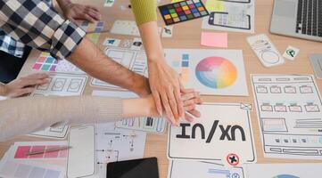 Creative professionals engaged in UX design brainstorming session, showcasing teamwork and innovative ideas. photo