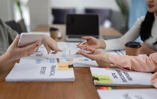 Women in a modern office discussing financial strategies and collaborating on reports. photo