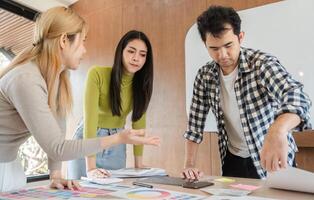 Diverse team collaborating on design project in modern office workspace. photo