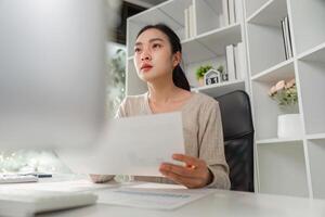 Concentrated office worker contemplating data and reports while managing stress in a professional setting. photo