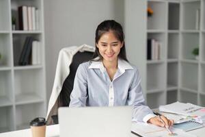 Finance professional smiling while working on a laptop in a modern office environment. photo