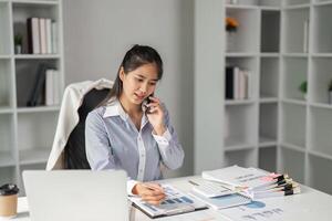 Finance professional analyzing data and making calculations in a modern office setting. photo