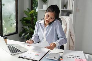 Focused accountant on a call, managing financial documents and calculations in a contemporary workspace. photo