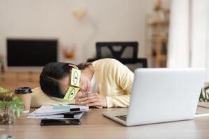 Exhausted woman resting her head on a desk, highlighting the need for a break in a busy workday. photo