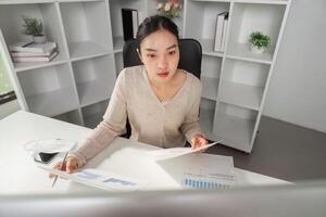 Office worker reviewing financial documents and charts, demonstrating focus and analysis. photo