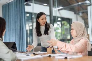 Women discussing financial strategies in a modern office setting, emphasizing teamwork and collaboration. photo