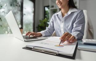 Detail-oriented financial expert working on a laptop, analyzing charts and data for effective decision-making. photo