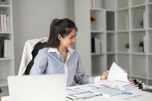 Finance professional organizing documents and analyzing data in a modern office setting. photo