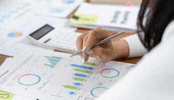 Financial worker analyzing budget reports with a calculator and charts in a modern office setting. photo