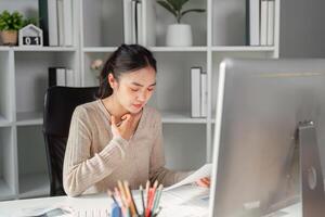 Office worker feeling unwell while reviewing documents at her desk. photo