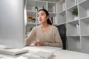 Focused office worker analyzing data and reports on a computer in a modern workspace. photo