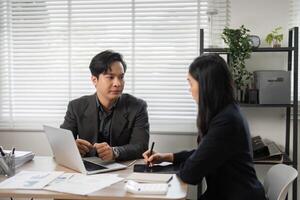 Diverse professionals discussing financial strategies in a bright office environment. photo