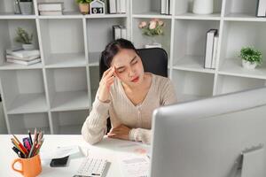 Stressed office worker dealing with financial data and reports in a modern workspace. photo