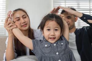 Child enjoying a playful moment with parents, showcasing family bonding. photo