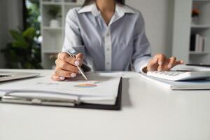 Accountant reviewing financial reports with a calculator, focusing on data analysis and strategy in a professional setting. photo