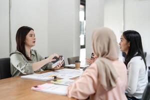 Diverse female professionals collaborating in a modern office meeting, discussing financial reports and strategies. photo