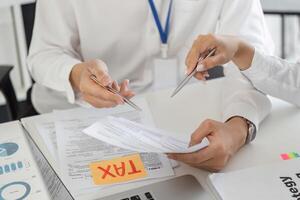 Team discussing tax forms and financial strategies in an office photo