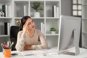 Office worker experiencing fatigue while staring at a computer screen, showing signs of stress. photo