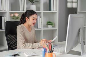 Diligent office worker preparing reports while managing multiple tasks at her desk. photo