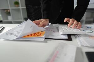 Accountant managing tax documents and calculations at a desk with a calculator. photo