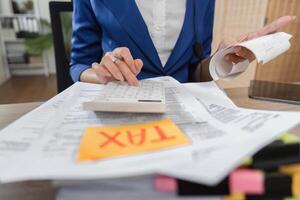 Professional accountant managing tax documents and calculations at a desk, showcasing financial diligence. photo