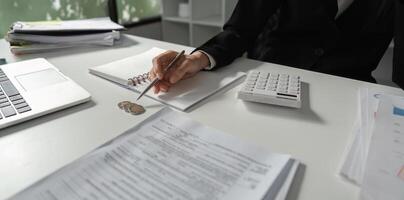 Accountant preparing financial statements and notes with a calculator and papers. photo