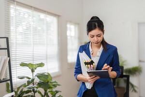 Accountant reviewing tax documents on a tablet in a modern office setting. photo