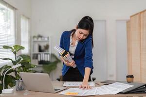 Accountant on the phone while managing tax documents and reports in a busy office. photo