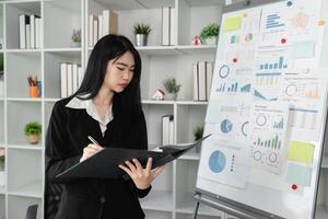 Focused accountant analyzing financial reports and charts in a modern office setting. photo