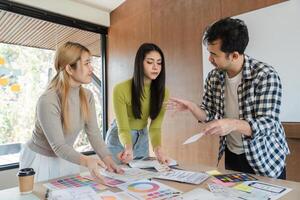 Diverse team collaborating on design concepts and discussing feedback in office. photo