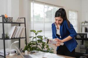Accountant reviewing tax documents while on a call in a contemporary office setting. photo