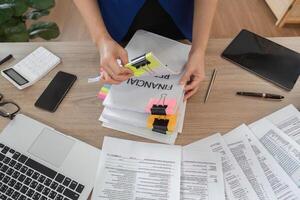 Accountant sorting financial documents and reports at a desk photo