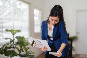 Accountant managing tax documents while on a phone call in a modern office. photo