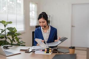 Detail-oriented accountant organizing tax paperwork while consulting clients in a modern office. photo
