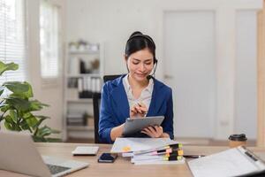 Accountant using a tablet to manage finances and communicate with clients in a bright workspace. photo